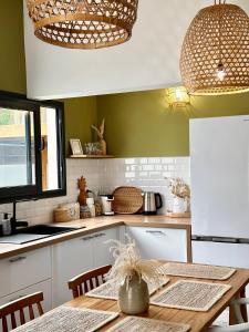 a kitchen with a wooden table in a kitchen at Villa Couleur Nature in Salazie +19 photos