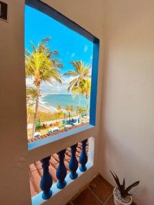 a window with a view of a beach with palm trees at Montepascual Ecovillage in Lagoinha +55 photos