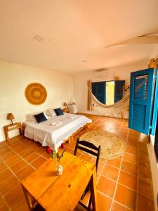 sypialnia z łóżkiem i drewnianym stołem w obiekcie Montepascual Ecovillage w mieście Lagoinha