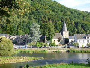 una pequeña ciudad con una iglesia y un río en Safaritent op Camping la Douane en Vresse-sur-Semois