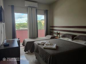 a hotel room with two beds and a window at Canastra Season in São Roque de Minas