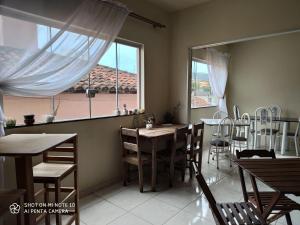 a dining room with a table and chairs and a window at Canastra Season in São Roque de Minas