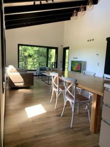una sala de estar con una mesa larga y sillas en Casa Condominio Pucon Villarrica, en Molco