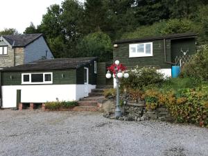 a house with a santa claus on top of a pole at Redwood Lodge, Dee Valley Stays - cosy microlodge with detached private shower & WC in Corwen