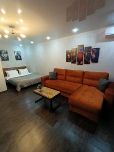 sala de estar con sofá y cama en Уютная и просторная квартира в 50 метрах от городского парка en Petropavlovsk