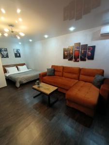 a living room with a couch and a bed at Квартира с видом на парк,в минуте ходьбы от Акимата,Налоговой, Прокуратуры,Рахмета,Dostyk Mall,ЦОНа in Petropavlovsk