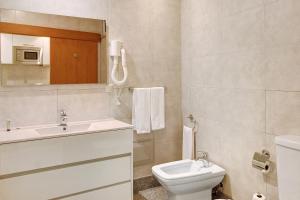 ein Badezimmer mit einem weißen Waschbecken und einer Toilette in der Unterkunft Dfm Happy Days F - Funchal in Funchal + 5 Fotos