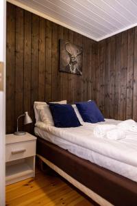 a bedroom with a bed with a wooden wall at Vollsnes Feriehus in Hjelle