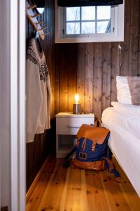 a bedroom with a bed and a backpack on the floor at Vollsnes Feriehus in Hjelle