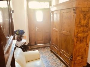 a living room with a large wooden cabinet and a couch at Hotel Weingut Dehren in Ellenz-Poltersdorf