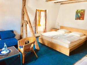 Hotel Weingut Dehren في إيلينز-بولتيرسدورف: غرفة نوم فيها سرير وكرسي