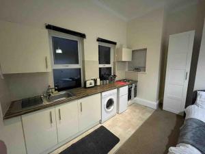 a kitchen with a sink and a washing machine at Modern studio apartment - great location! in Mansfield