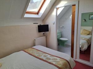 a bedroom with a bed and a bathroom with a window at Diamond House in Rugby