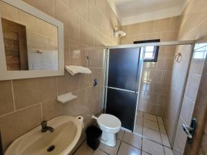 a bathroom with a shower and a toilet and a sink at Pousada Genoveva - Casa a beira mar in Laguna +9 photos