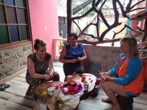 three women sitting around a table with a cake at POSADA KAUAI in Mocoa