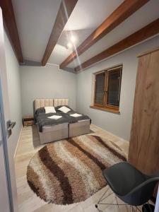 1 dormitorio con cama y alfombra en Agroturystyka Dom Skowronek en Legbąd