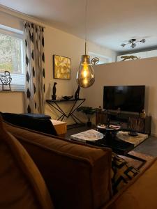 uma sala de estar com um sofá e uma televisão de ecrã plano em City Prüm em Prüm