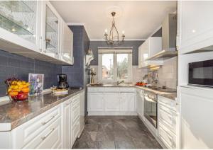 a kitchen with white cabinets and granite counter tops at Royal Apartments Sandra in Štinjan
