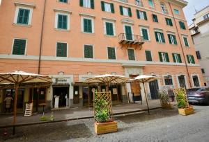 a large building with umbrellas in front of a street at Intra' Residenza in Trastevere in Rome