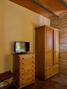 a television sitting on top of a wooden dresser at Hostal meson del rey in Olocau del Rey