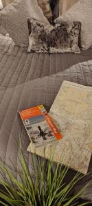 a map and a book sitting on a bed at Cosy Country Retreat in the Brecon Beacons in Crickhowell
