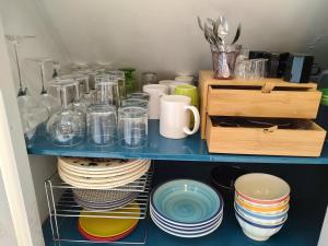 a blue shelf with plates and cups and dishes at Studio au 2e étage de notre maison de ville in Caen