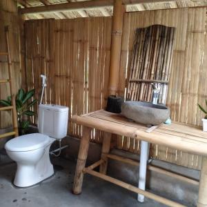 a bathroom with a toilet and a sink at Girang Rinjani Bungalows in Tetebatu