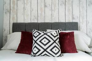 a pile of pillows sitting on top of a bed at Derby Road Suite in Kegworth