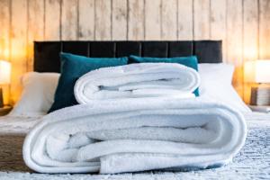 a pile of white towels sitting on top of a bed at Derby Road Suite in Kegworth