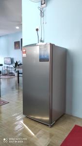 a stainless steel refrigerator sitting in a room at Ain's Homestay in Kangar