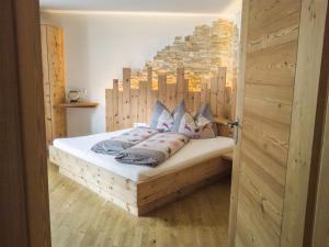 a bedroom with a bed with a wooden headboard at Beim Gruber in Melago