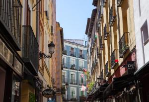 a narrow street with buildings in a city at Apartment a few steps from Puerta del Sol in Madrid