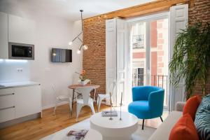 a living room with a table and a blue chair at Apartment a few steps from Puerta del Sol in Madrid