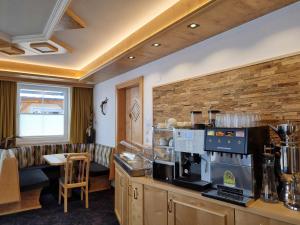 a coffee shop with a counter with a coffee maker at Hotel Garni Corinna in Ischgl