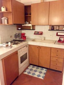 a kitchen with wooden cabinets and a stove top oven at Ponza Holiday Homes - Porto in Ponza