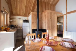 a kitchen with a wooden table with a fireplace at CityKamp Colmar in Horbourg