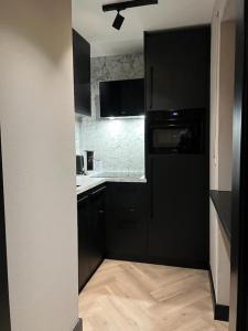 a kitchen with black cabinets and a stove top oven at Zum Polz in Winterberg