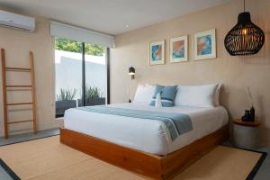- une chambre avec un grand lit et une fenêtre dans l'établissement Illa Cozumel, à Cozumel