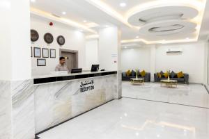 a lobby of a hotel with a man standing at a counter at DUQUM PLAZA HOTEL in Duqm