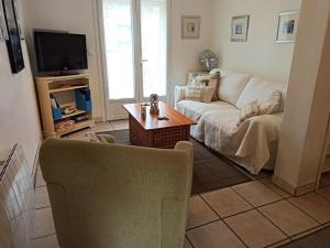 uma sala de estar com um sofá e uma mesa em Well equipped apartment, large terrace, BBQ & WIFI em Ria