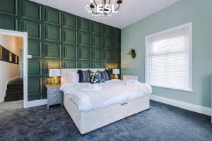 um quarto com uma parede em tons de verde e uma cama em Stylish 3 Bedroom Townhouse close to Chester City Centre - Ideal for Families, Groups and Contractors em Hough Green