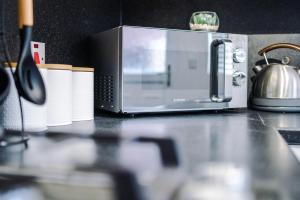 a kitchen counter with a toaster oven and paper towels at Stylish 3 Bedroom Townhouse close to Chester City Centre - Ideal for Families, Groups and Contractors in Hough Green