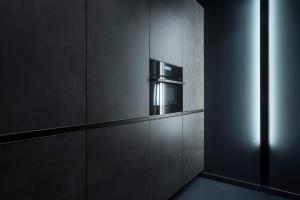 a black kitchen with a microwave in a wall at Lava in Donostia-San Sebastián +21 photos