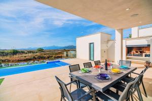 uma sala de jantar com mesa e cadeiras e uma piscina em Villa Corb Mari II em Playa de Muro