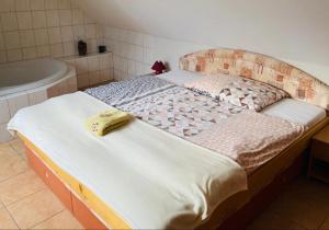 łóżko w pokoju z wanną i łóżko z materacem w obiekcie Vila Safin w Popradzie