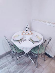 una mesa blanca con sillas y platos. en Vila Safin, en Poprad