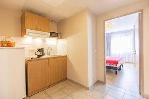 a kitchen with a sink and a room with a bed at Appart'City Confort Strasbourg Centre in Strasbourg