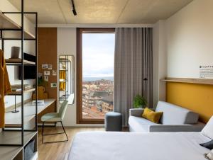 um quarto de hotel com uma cama e uma janela em Kora Green City - Aparthotel Passivhaus em Vitoria-Gasteiz