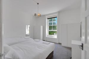 ロンドンにあるHamilton Apartments hosted by Maysa Londonの白いベッドルーム(ベッド2台、窓付)