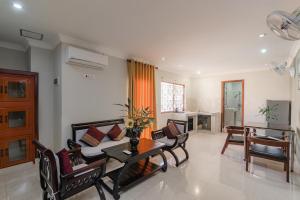 sala de estar con sofá, mesa y sillas en Sinaka Angkor Hotel, en Siem Reap